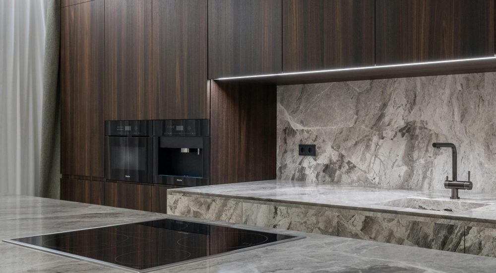 Interior design of spacious stylish modern kitchen with induction stove and air extraction system with wooden cupboards
